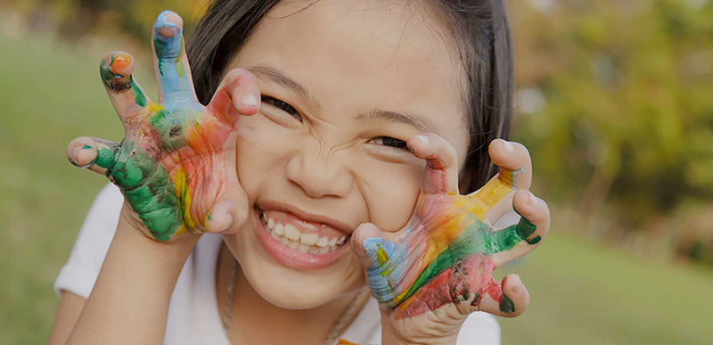 happy young girl with paint on her hands